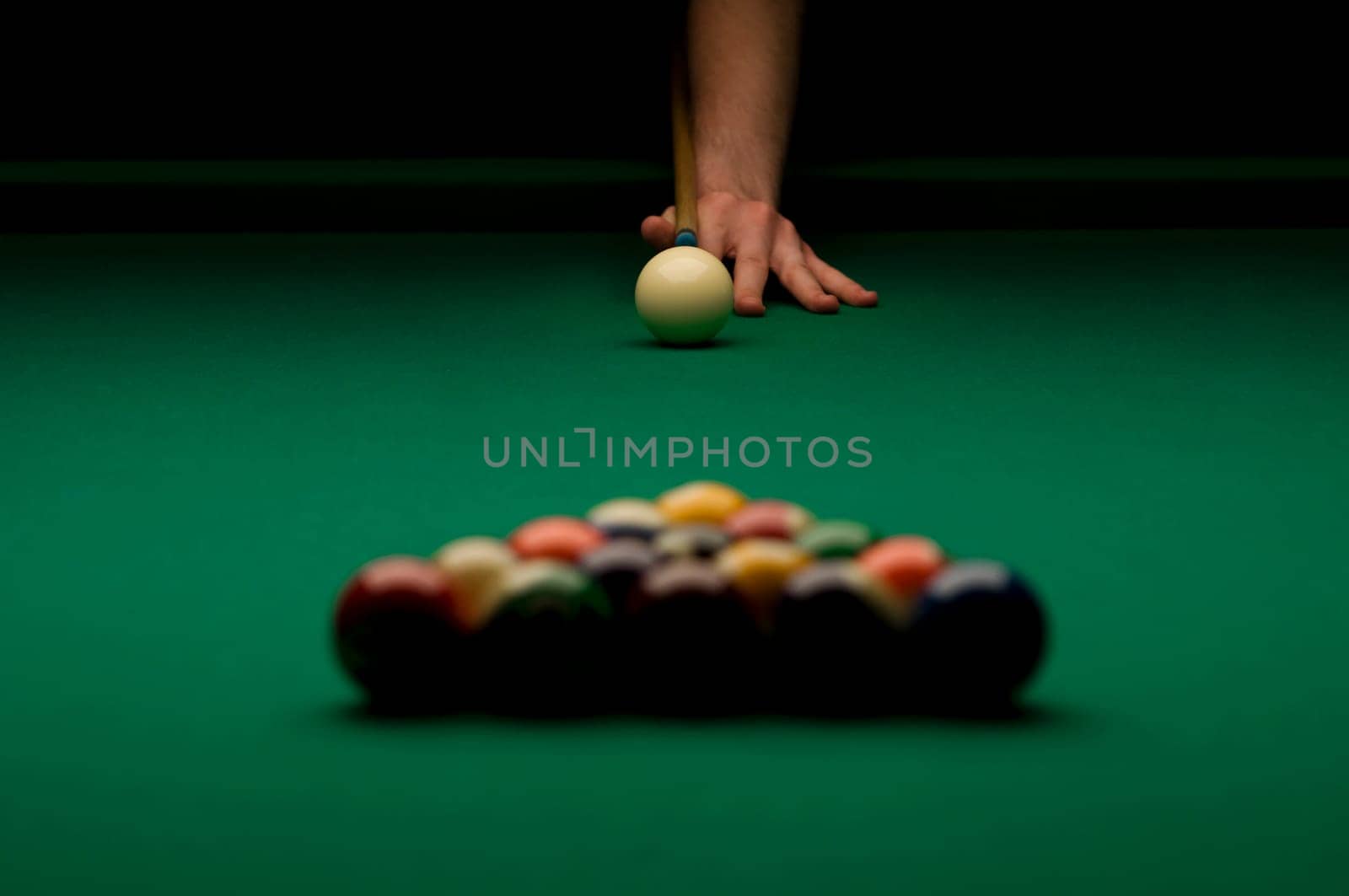 Person's hand ready to break billiard balls.