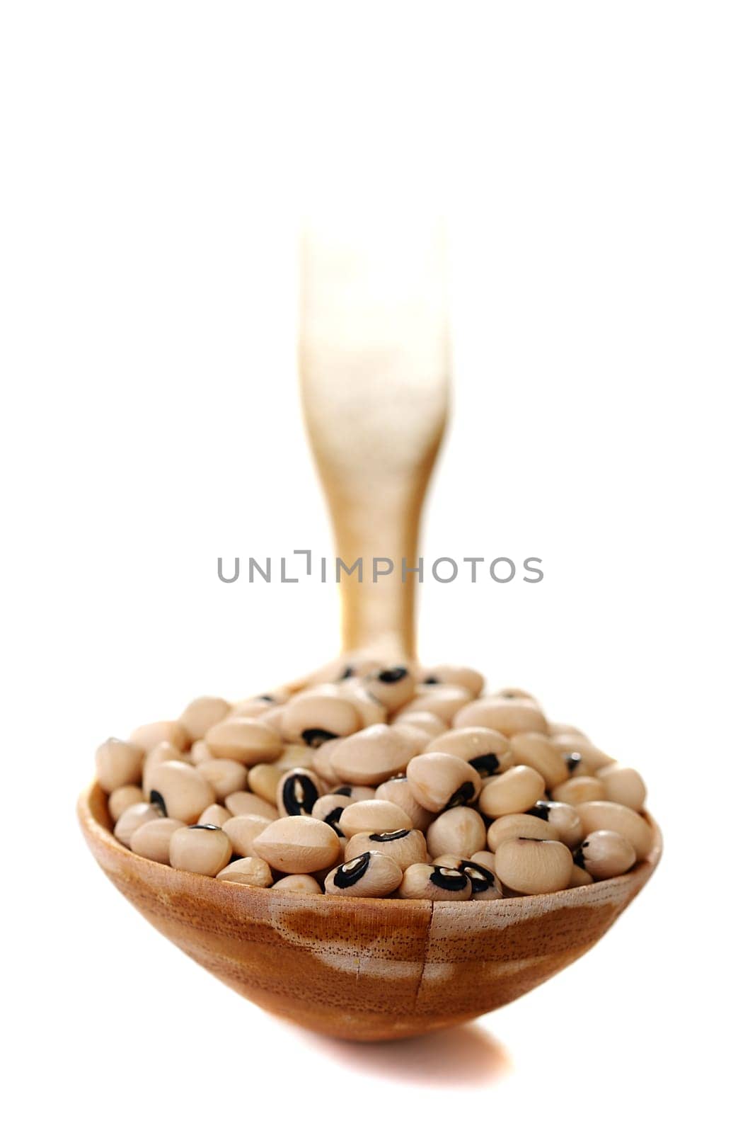 White beans in a wooden spoon islated on a white background.