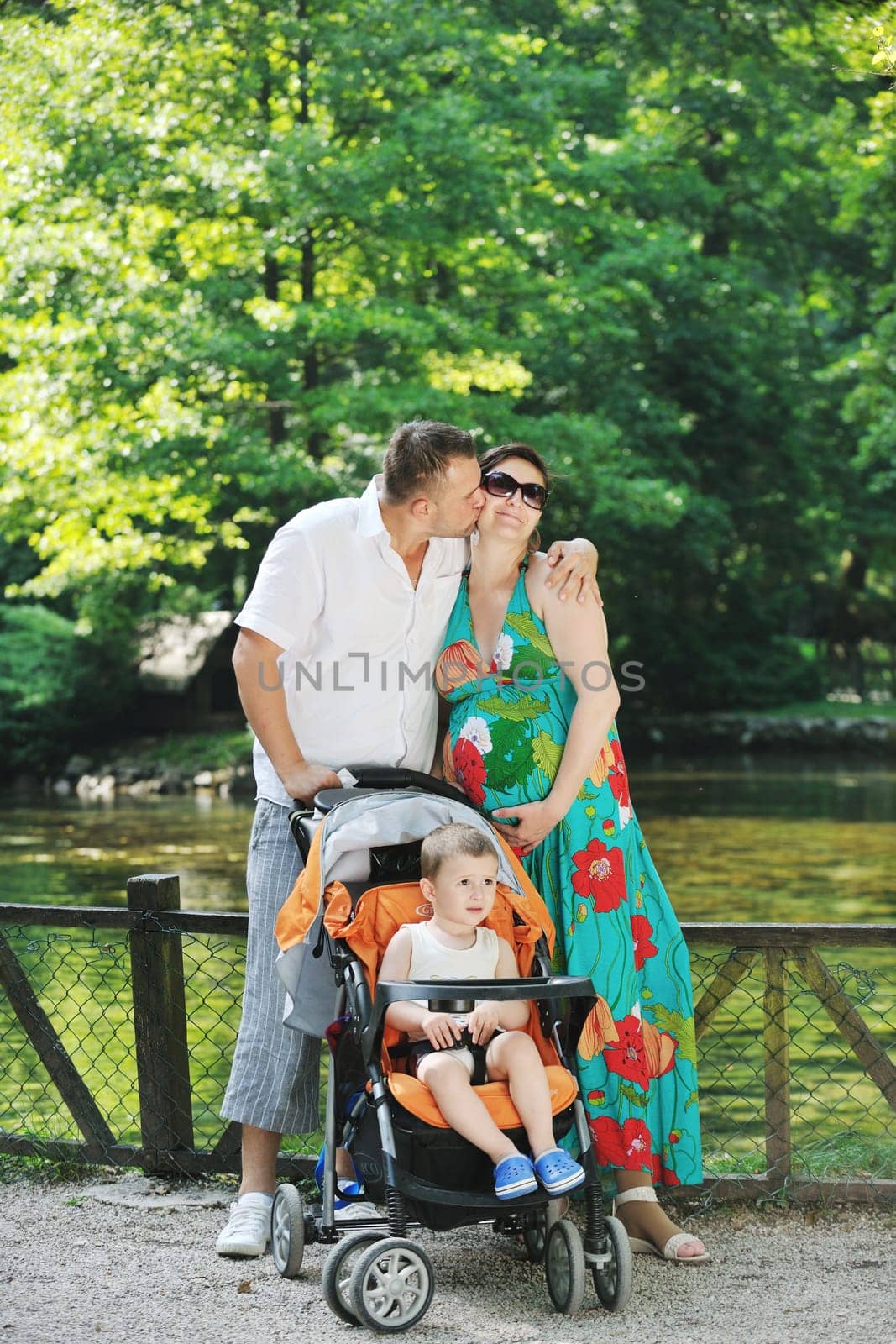 Happy young Family at park relaxing and have fun with pregnant woman