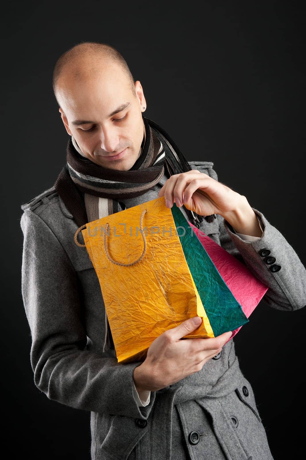 Young man with shopping bags in the dark