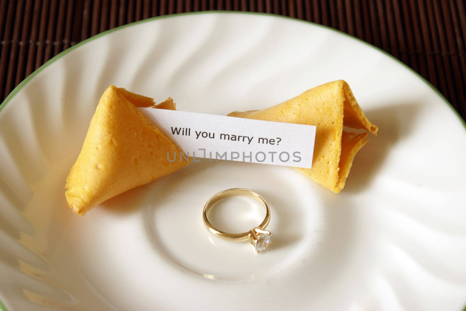 A marriage proposal using a fortune cookie and gold ring.
