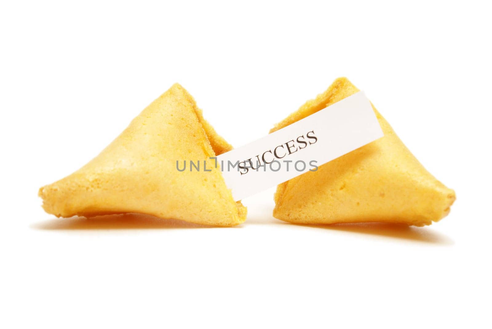 A cracked open fortune cookie stating the word success.