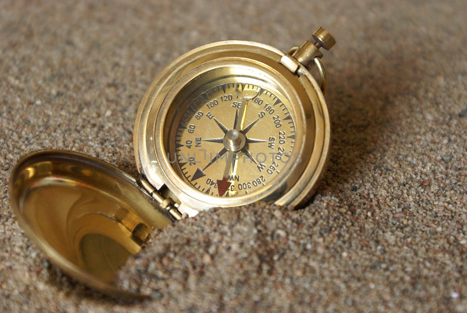 A conceptual image of a compass in the sand to amplify being lost.