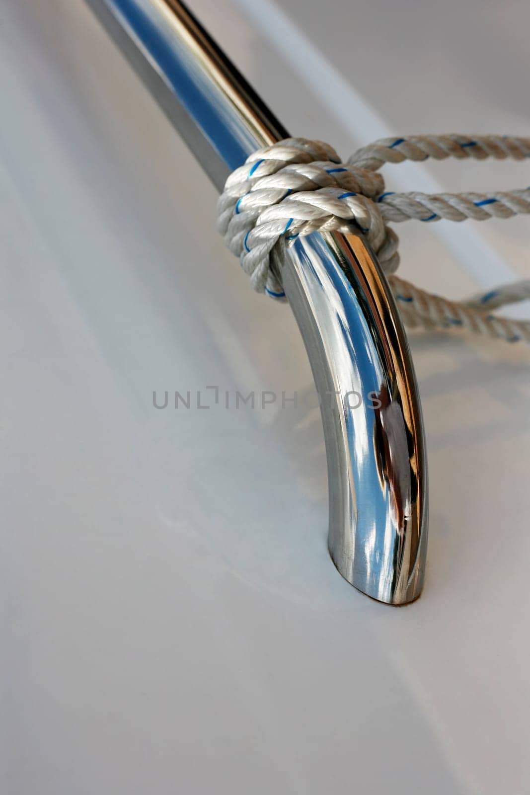 Ropes tied up on a bitt of a white boat