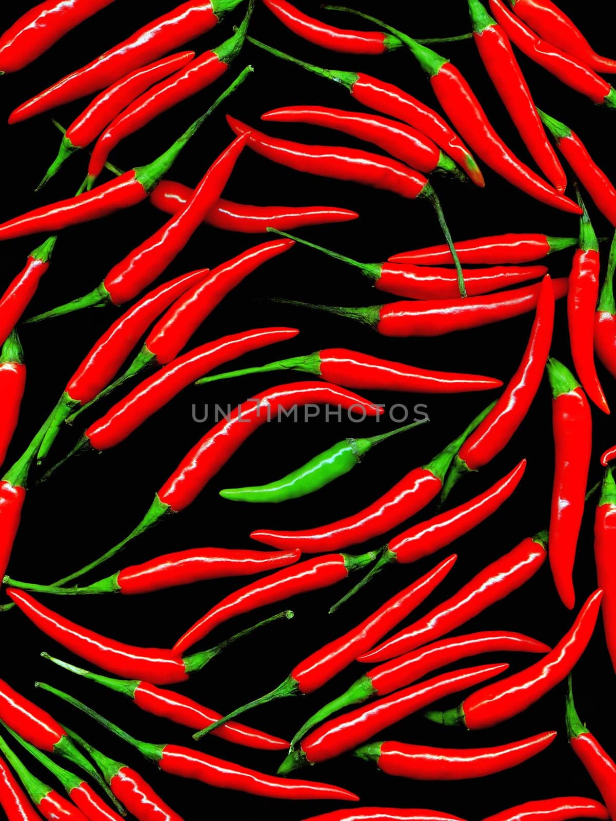 bounch of red chili peppers and a green one on the middle on black background