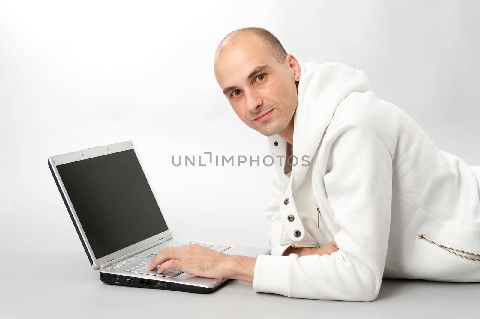 Portrait of a young man using a laptop, gray background