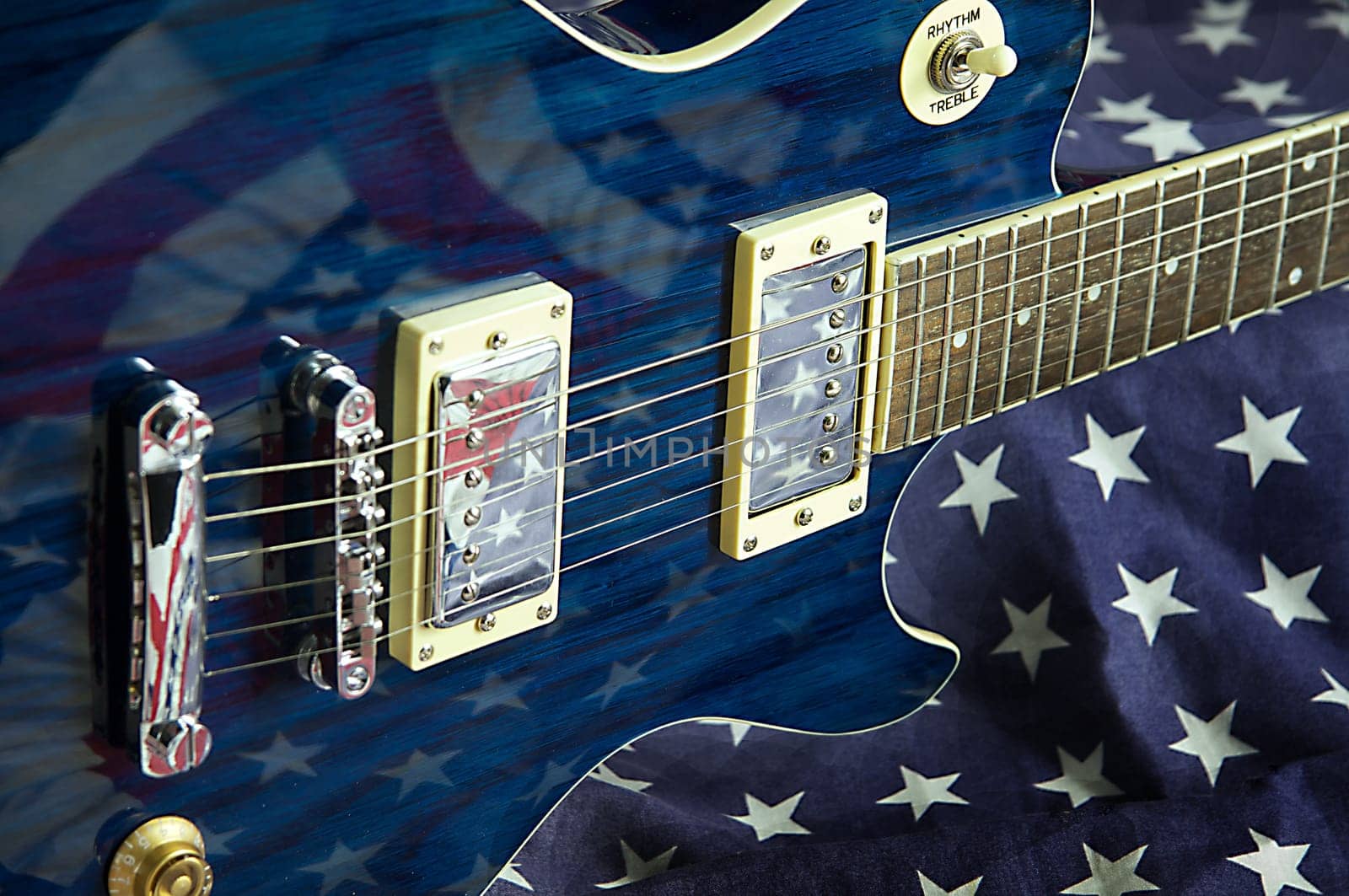 A blue wood electric guitar shot on an American flag background in the horizontal format.