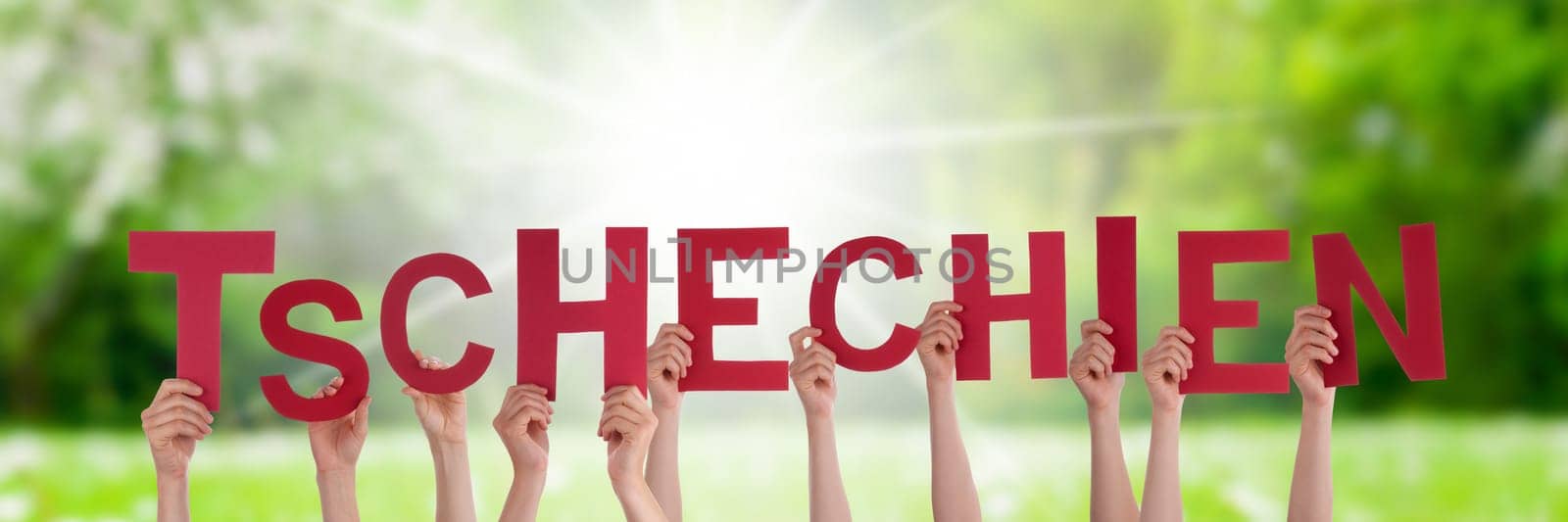People Or Persons Hands Building German Word Tschechien Means Czech Republic. Sunny Green Grass Meadow As Background.