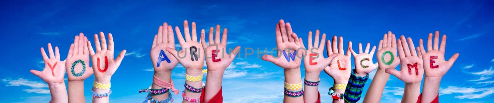 Children Hands Building Colorful English Word You Are Welcome. Blue Sky As Background.