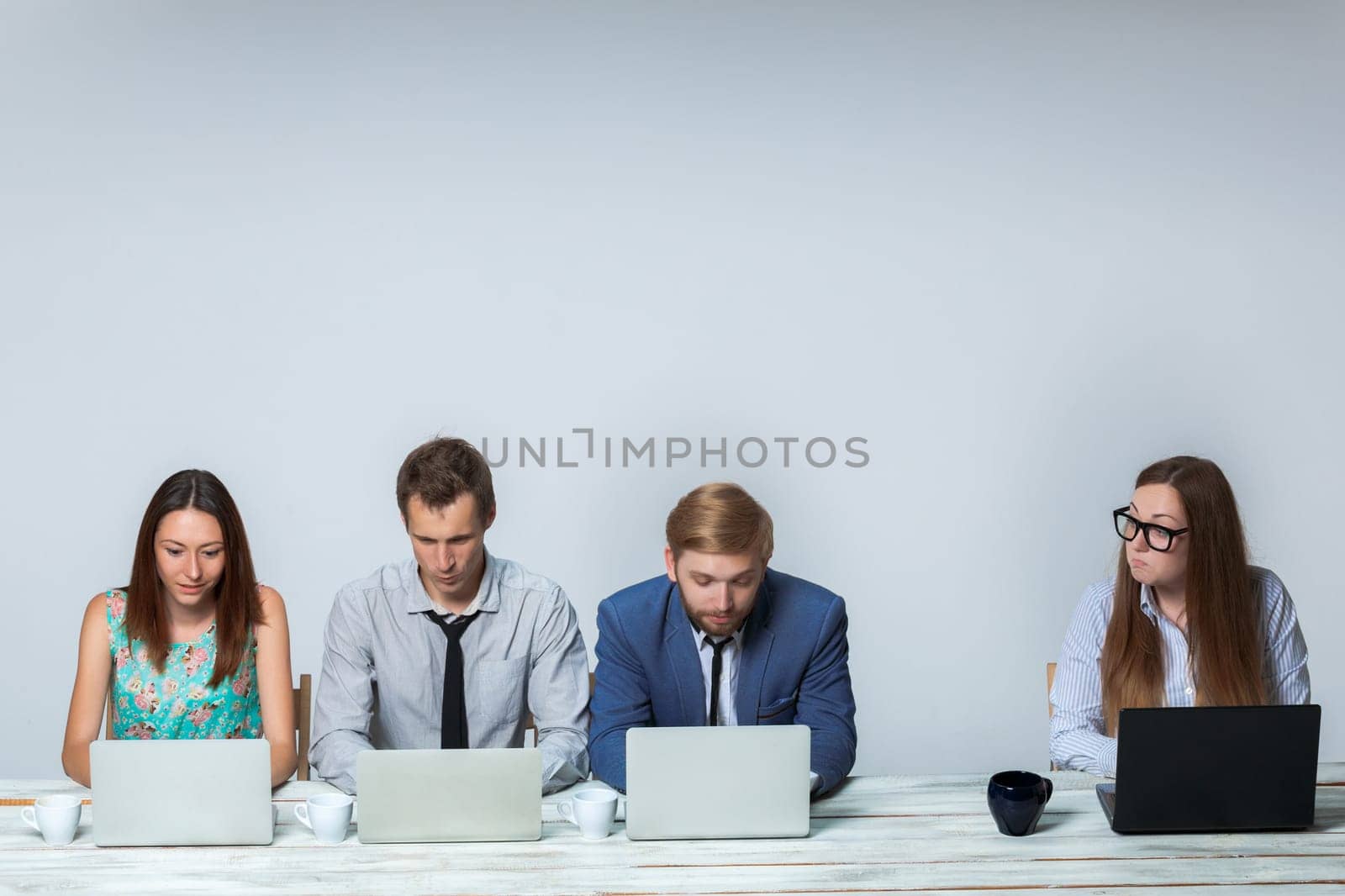 Business team working together at office on light gray background. all working on laptops. copyspace image