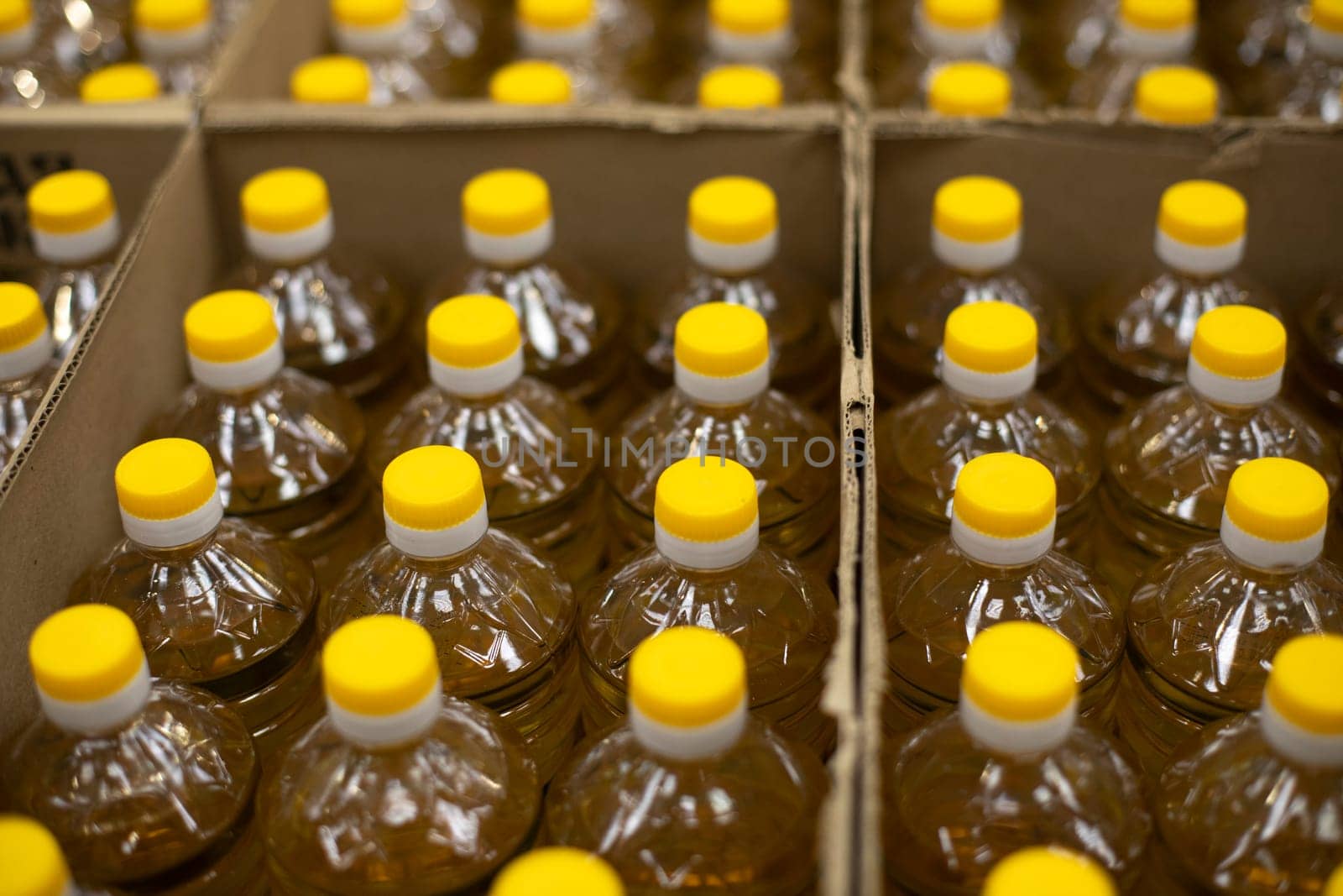 Sunflower in box. Bottles stand in row. Yellow bottle stoppers. Goods in stock.