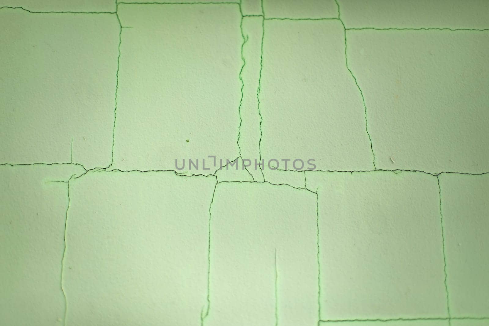 Cracks on wall. Scratches on green background. Old paint. Surface crack.