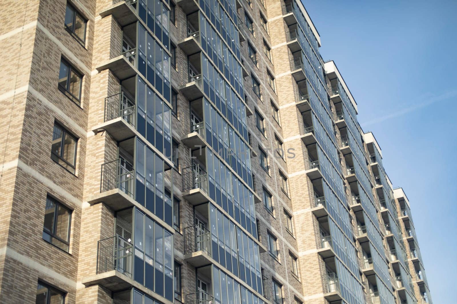 Windows in new building. Apartment building in city. New housing. Glazed balconies.