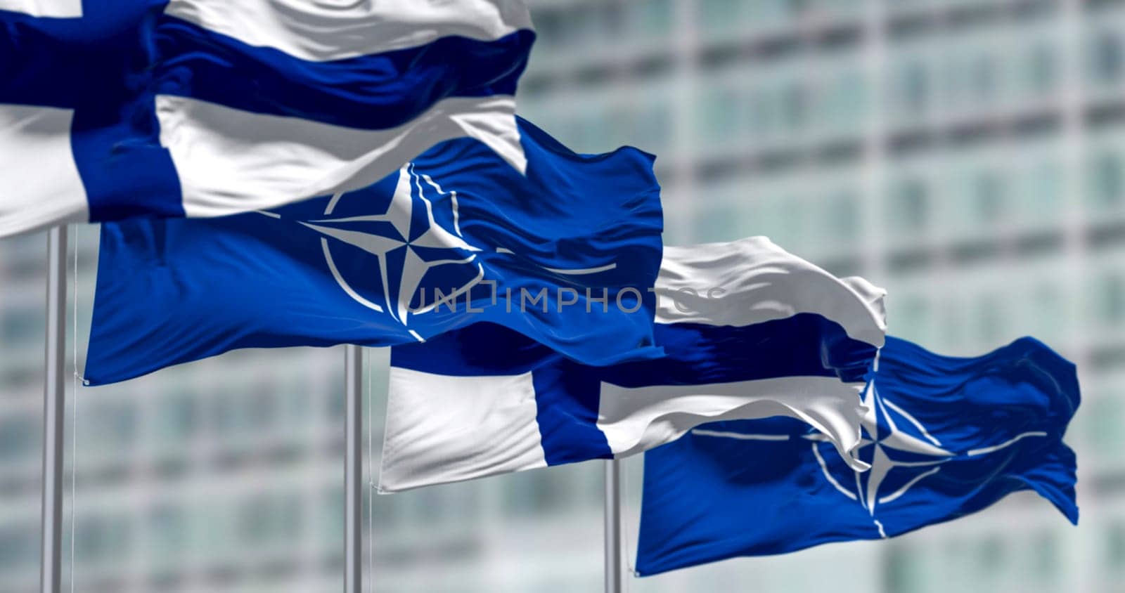 Brussels, BL, April 2023: The flags of Finland and NATO waving in the wind. Finland became the 31st member of NATO on April 4, 2023. Illustrative editorial 3d illustration render