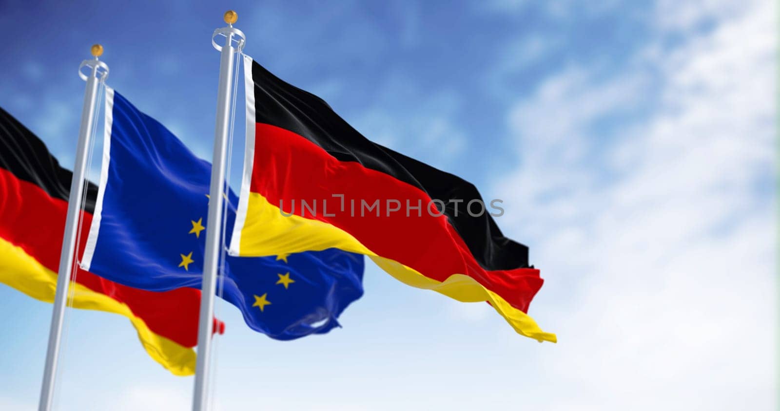 The flags of Germany and the European Union waving together on a clear day. Germany became a member of the European Union on January 1, 1958. Realistic 3d illustration
