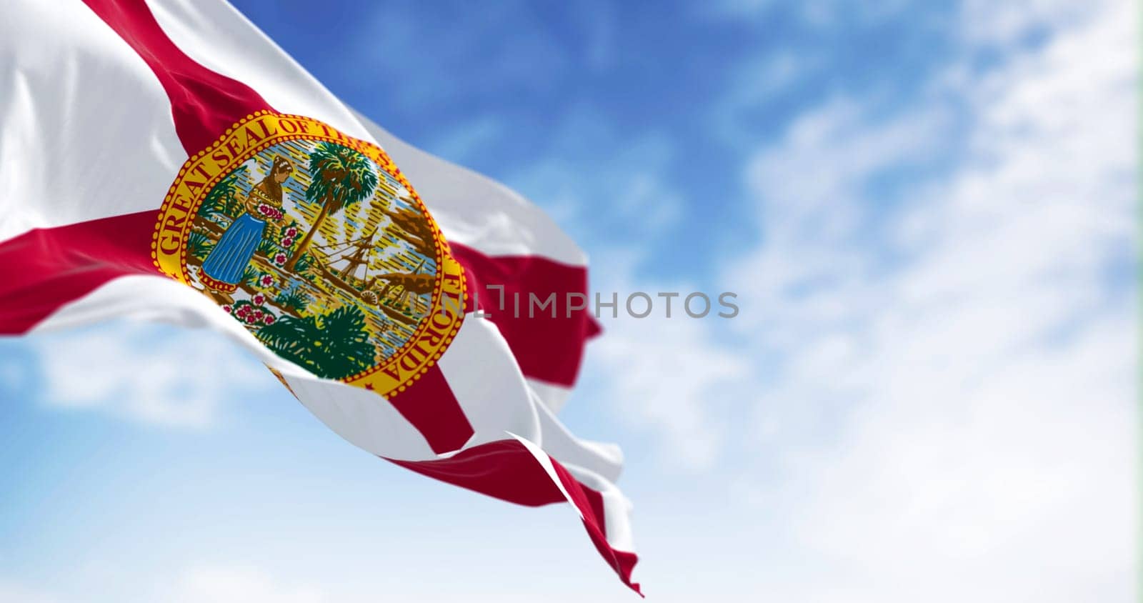 Close-up view of the Florida state flag waving in the wind on a clear day. Red saltire on white with the state seal in the center. 3d illustration render. Selective focus.