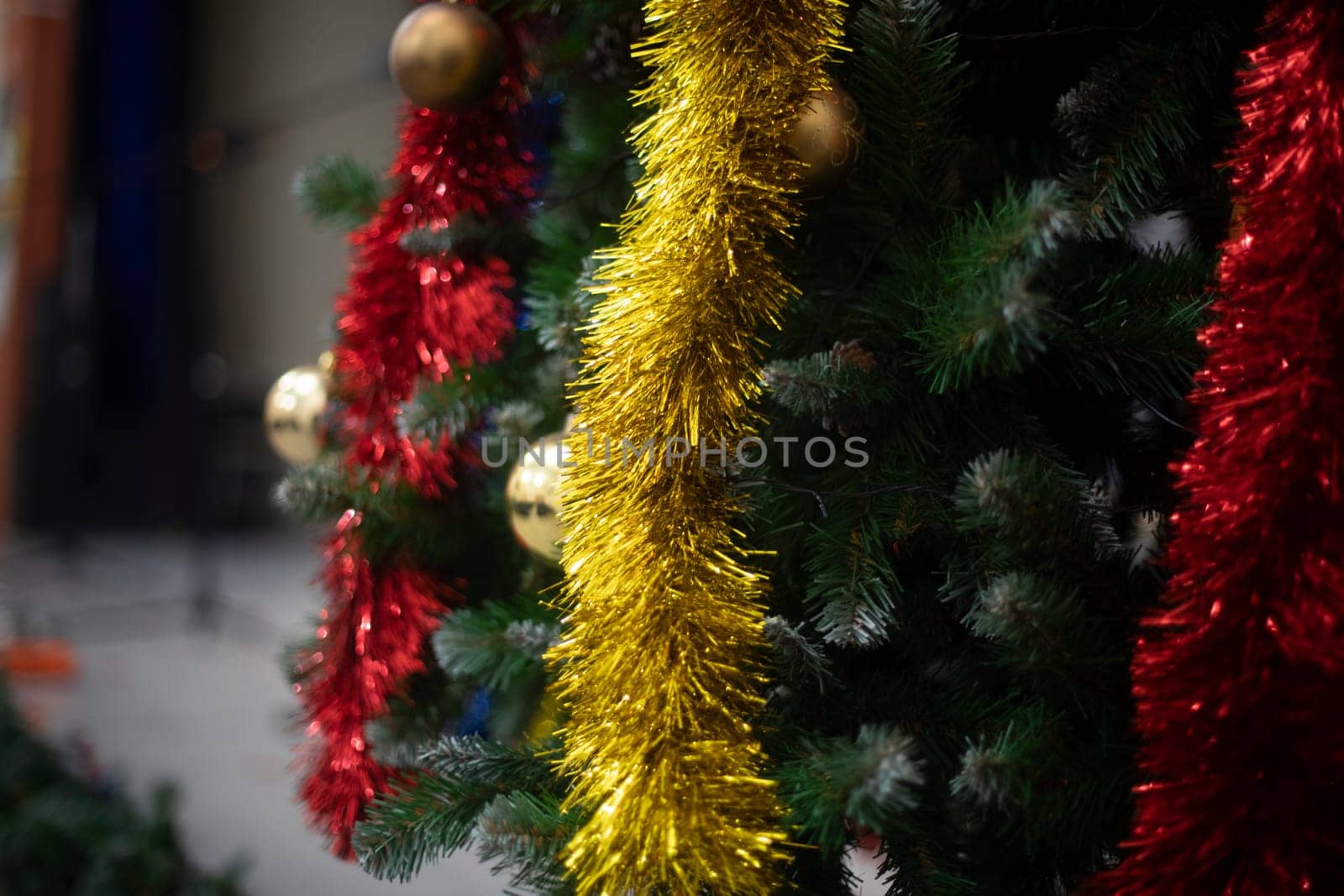 Toys and garlands for Christmas. Decorations on Christmas tree. Garlands on tree. Details of holiday.
