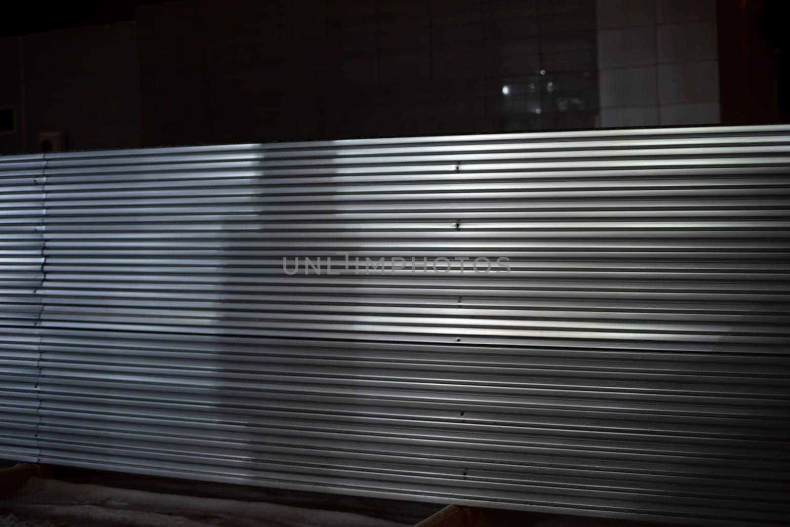 Steel fence at night. Fence in evening. Industrial zone. Metal sheet.