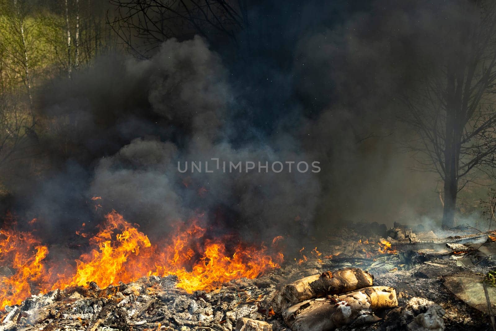 Fire in landfill. Fire and smoke. Burning garbage. Lots of black smoke.