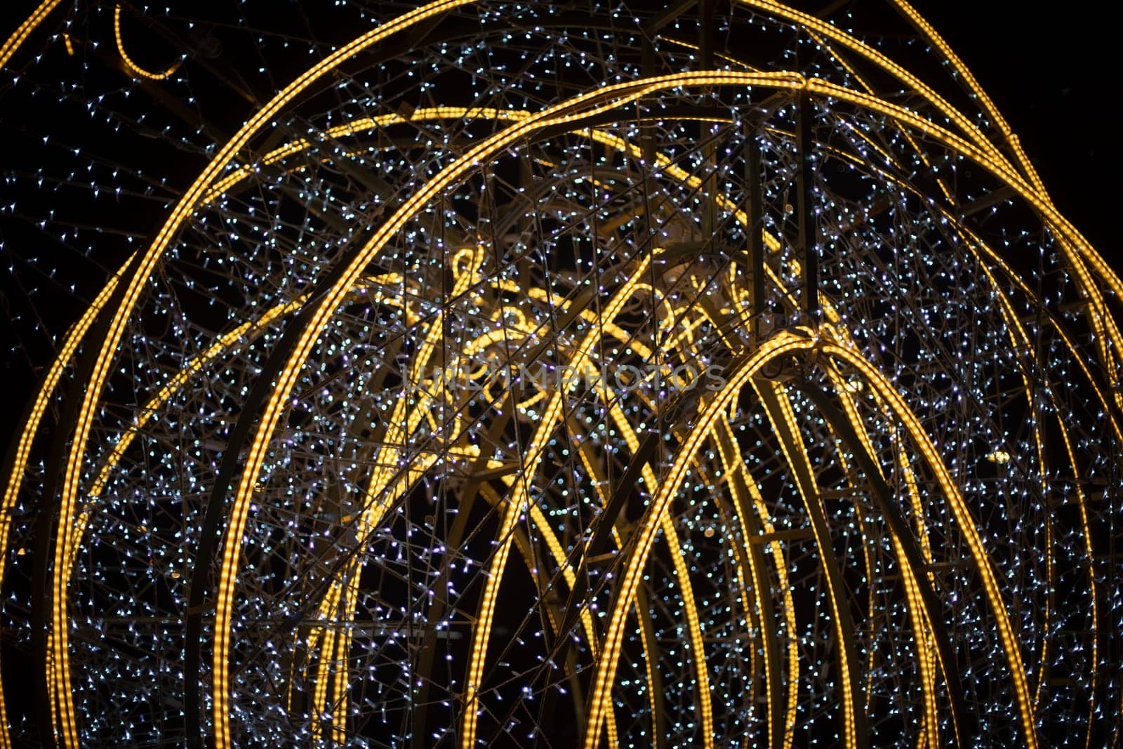 Design with lamps. Bright construction in city. Garlands on capital frame.