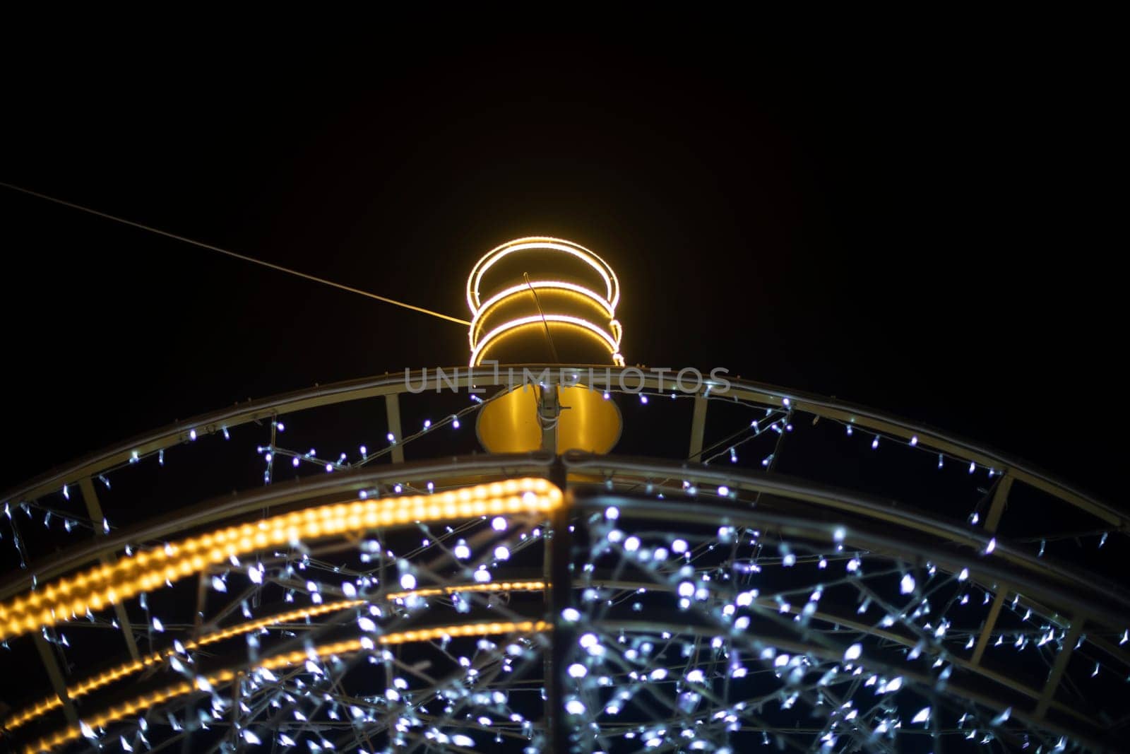 Garlands are arranged in arc. Urban decoration. Bright light bulbs. Garland construction.