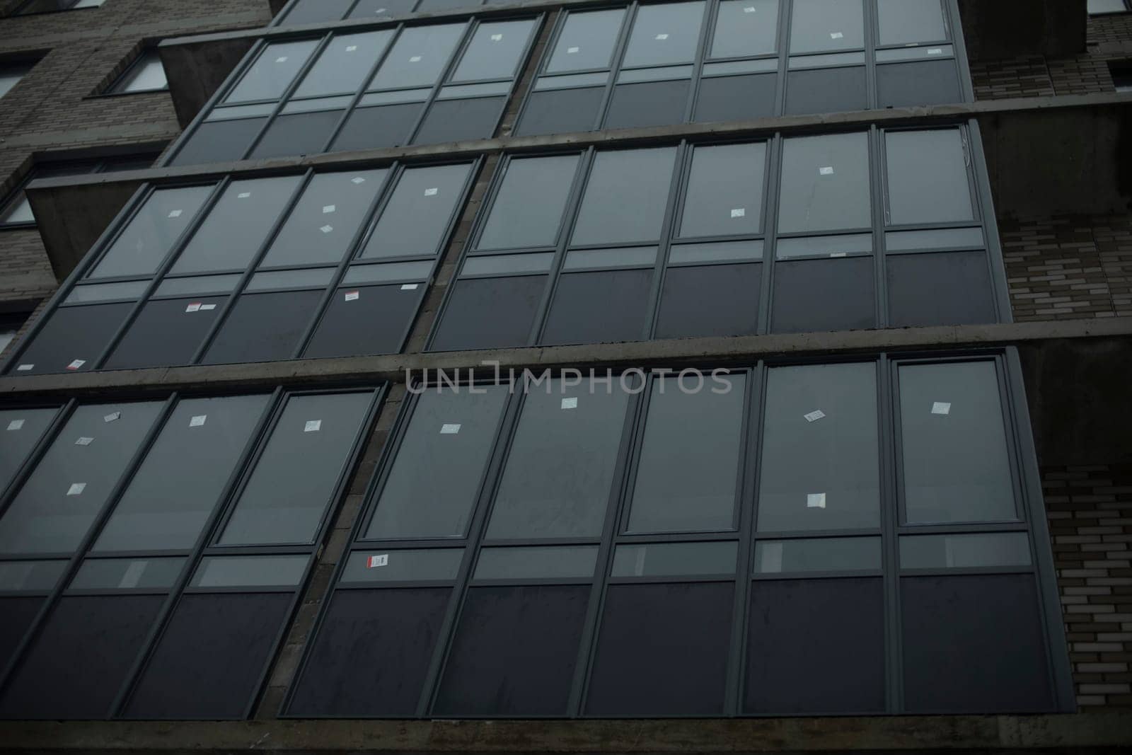 New windows in building. Balconies in house. New residential building. Details of construction.