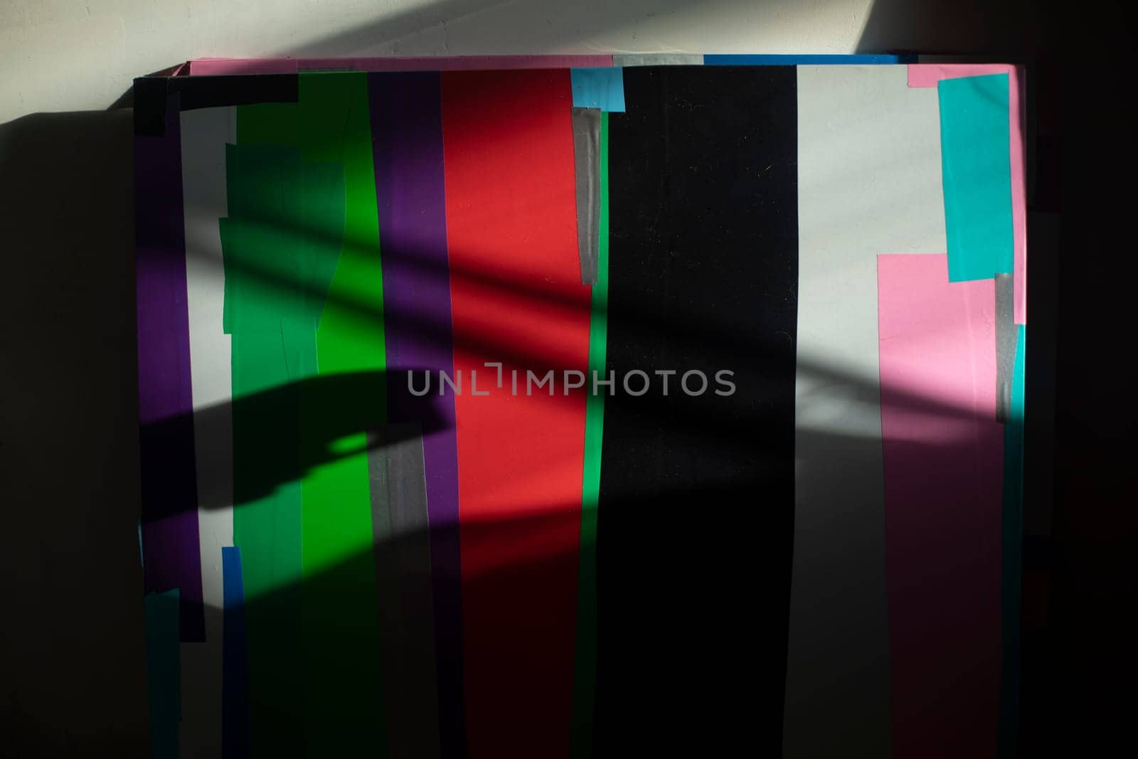 Abstract picture of colored flaps. Chaotic drawing on canvas. Drawing with film. No symmetry in arrangement of crooked scraps.