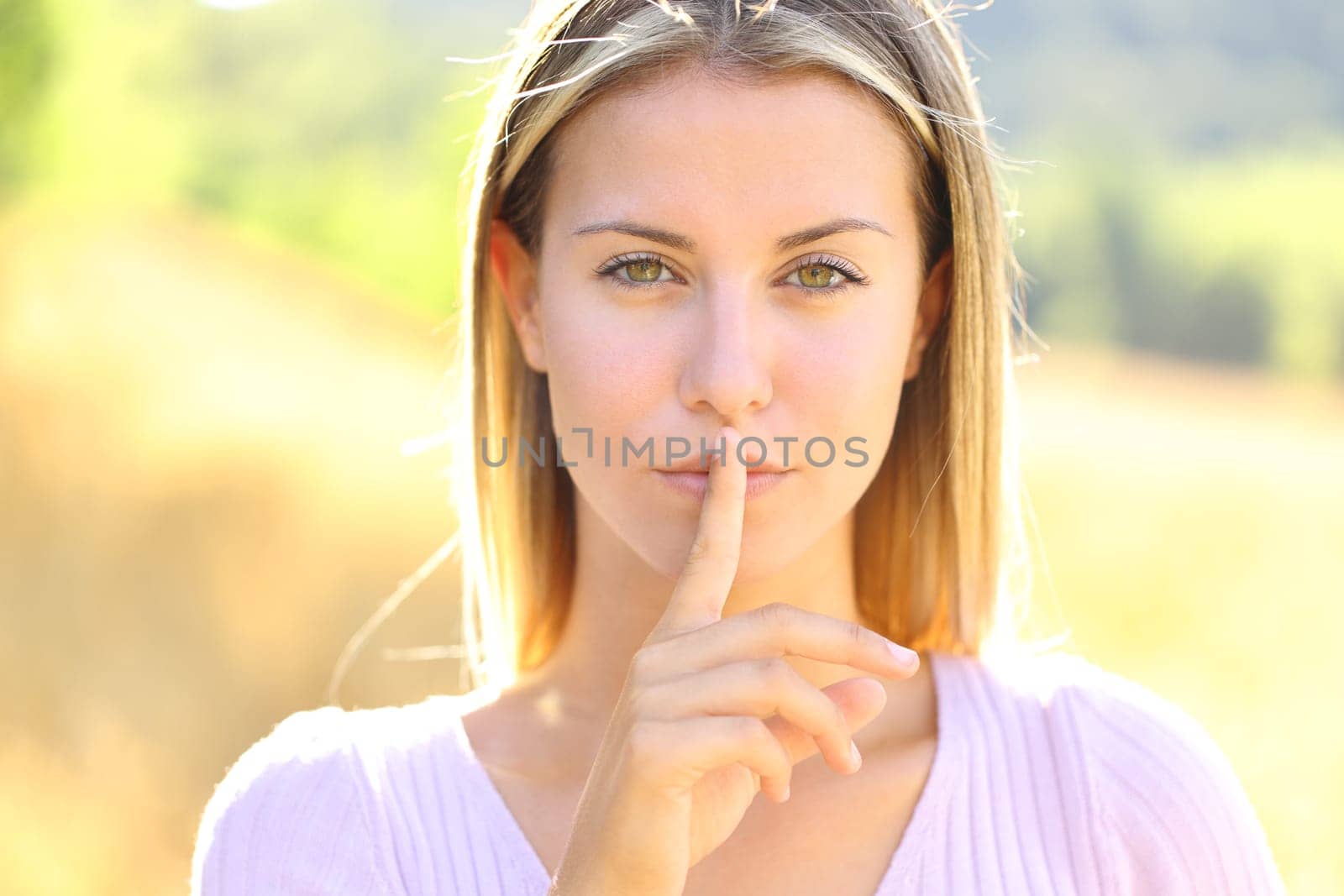 Front view portrait of a beautiful woman asking for silence in nature