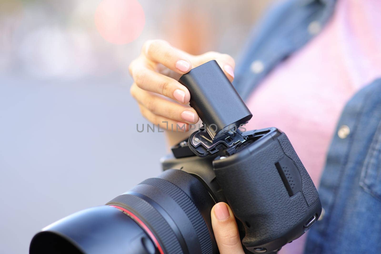 Close up portrait of a photographer changing battery on camera