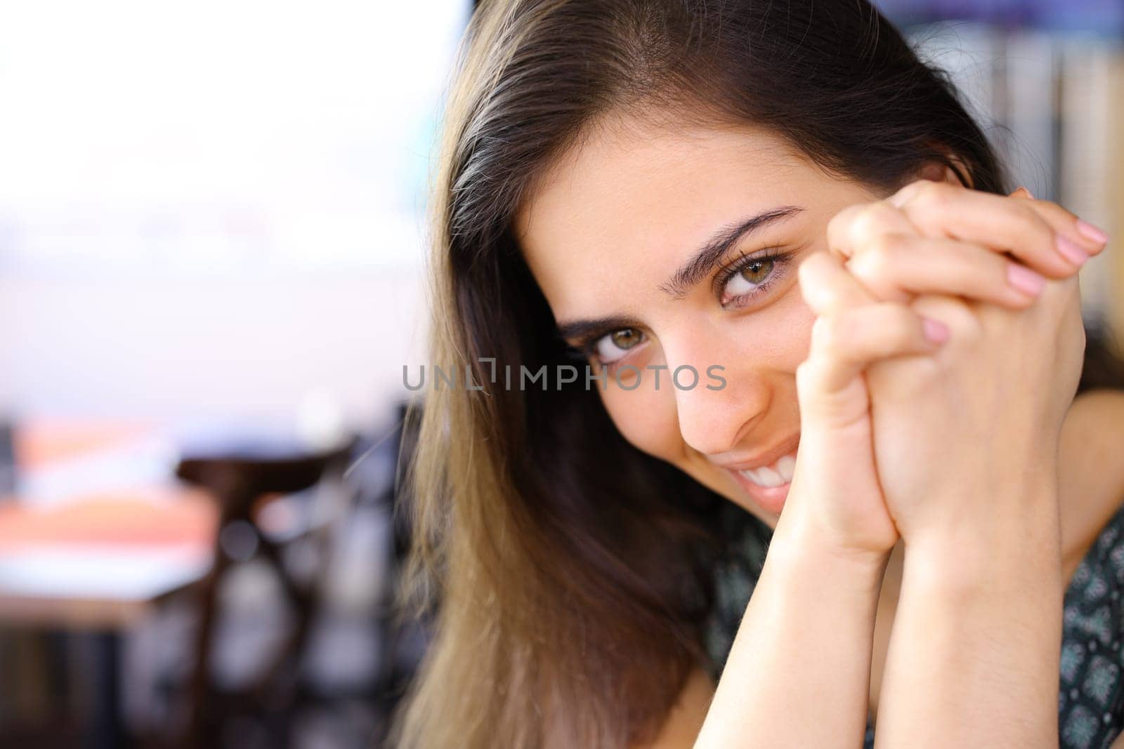 Timid woman looking at you sitting in a restaurant