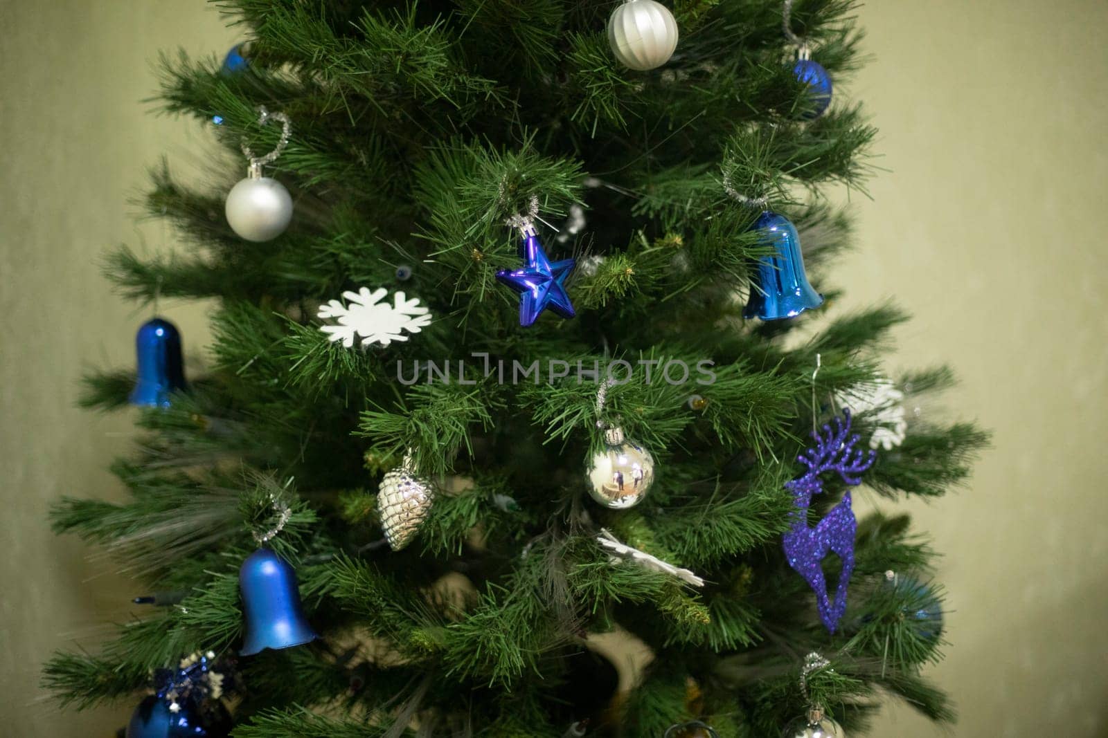 Blue decorations on Christmas tree. Christmas tree toys of blue color. Christmas tree in apartment. Christmas Holiday Details.