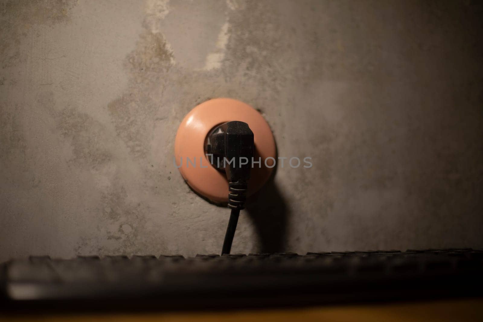Plug in socket. Electricity at home. Black cable. Wires in apartment.