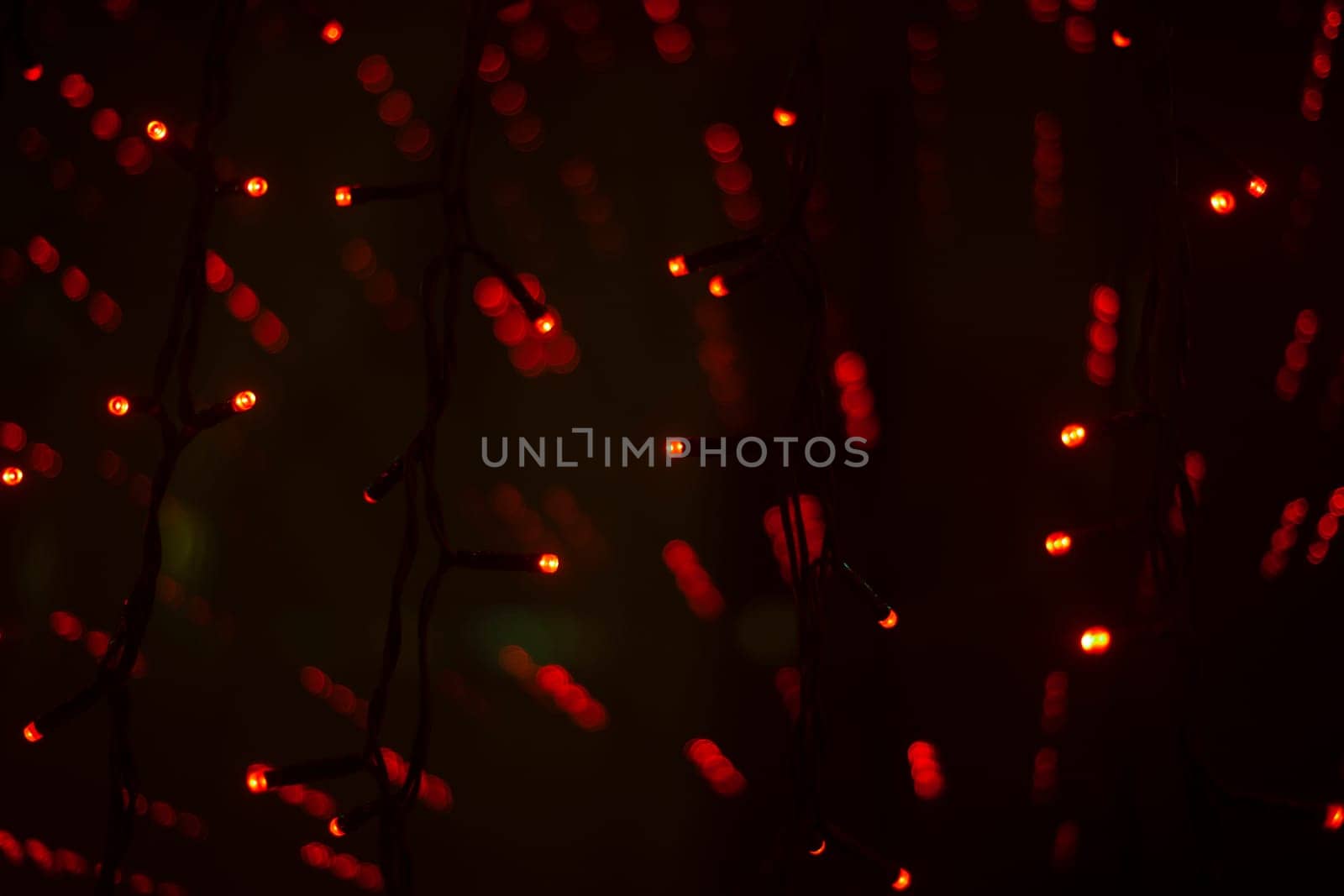 Red garlands in interior. Lights in dark. Room details. Light on window. Red lights shine.