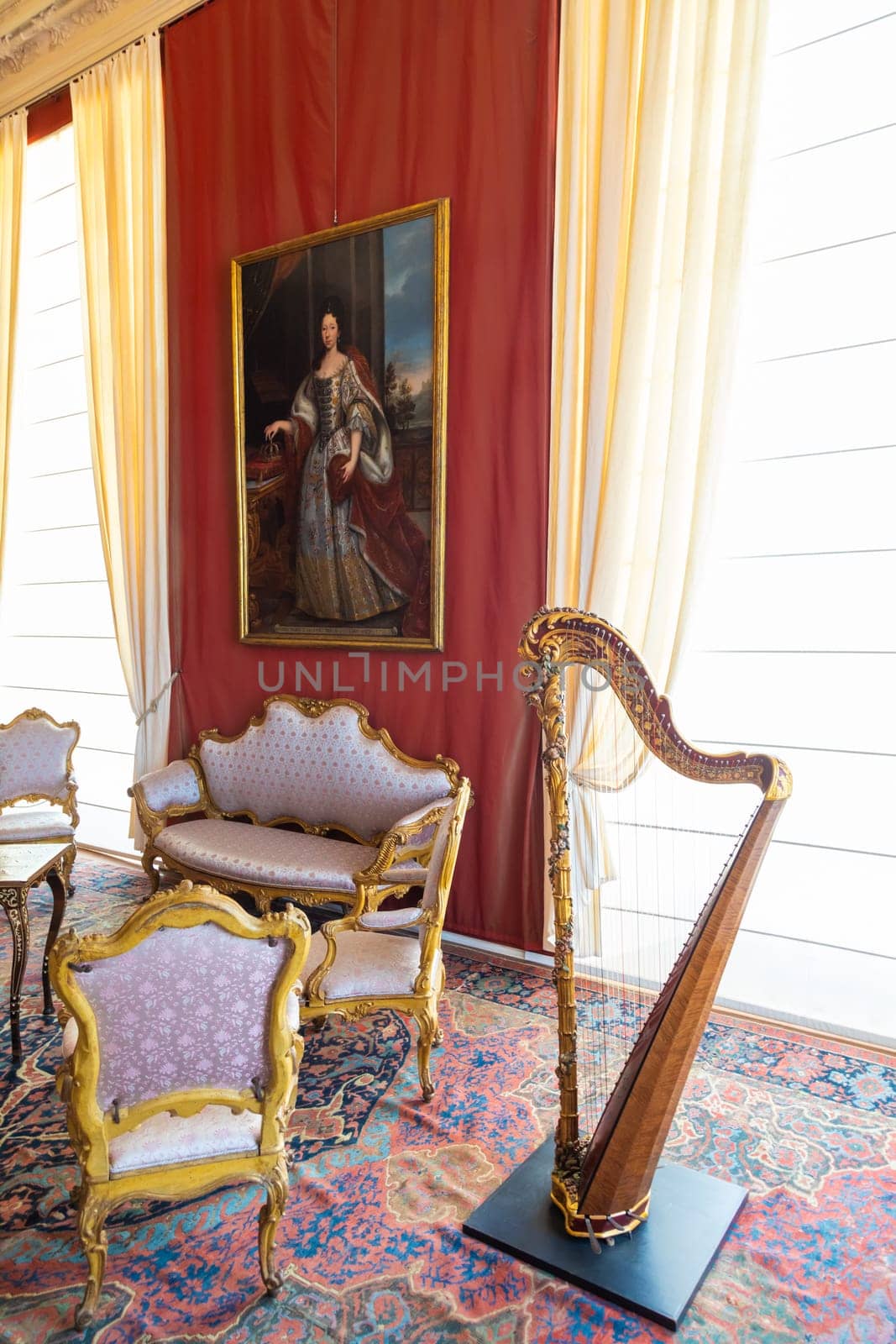 Venaria Reale, Italy - February 2023: luxury interior, old Royal Palace. Perspective with harp, window and baroque decoration.