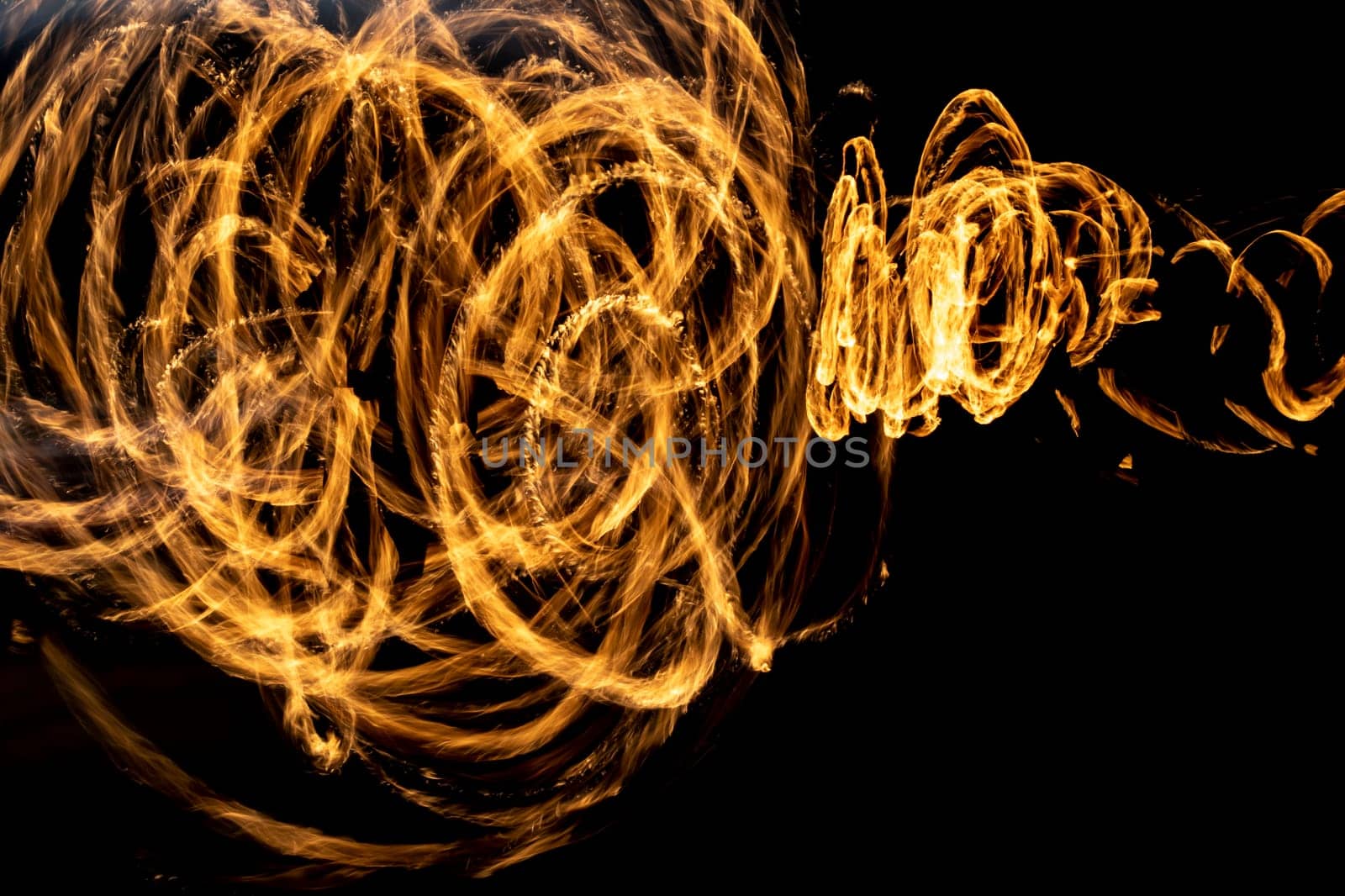 Flames on long hatchet. Traces of fire in dark. Flames spread chaotically in space.