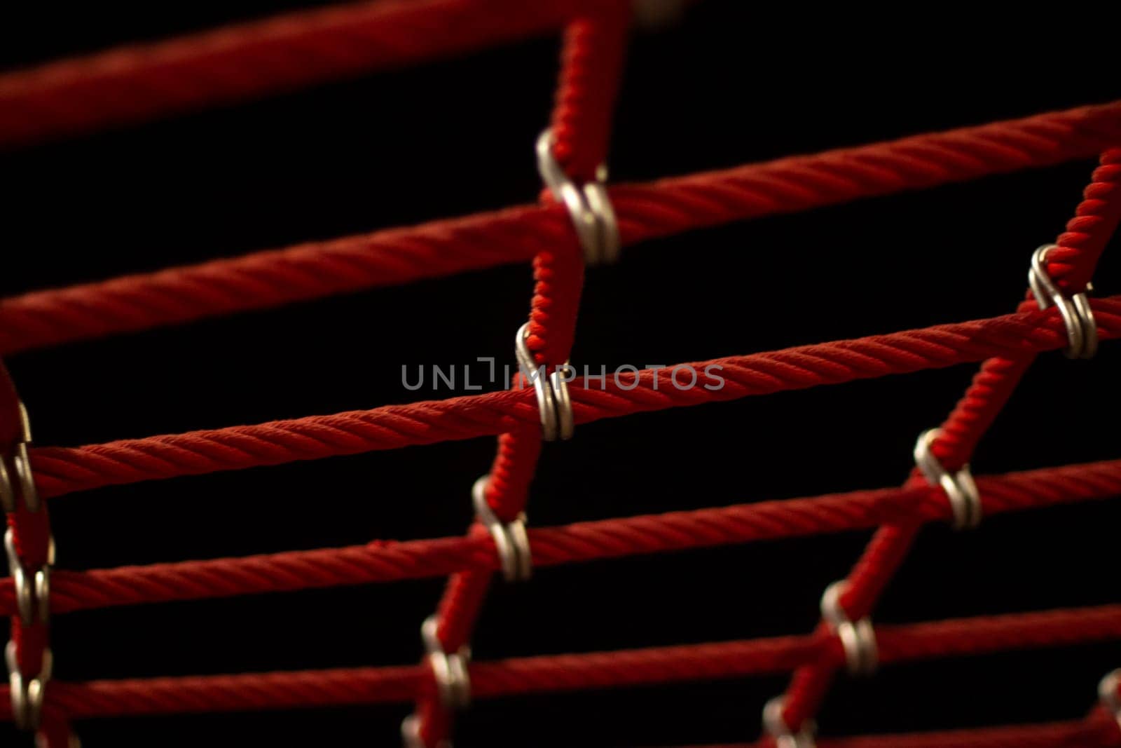 Ropes in the playground. Climbing net, shot close-up. Ropes fastened with links. Rope texture shot at night in street lighting.