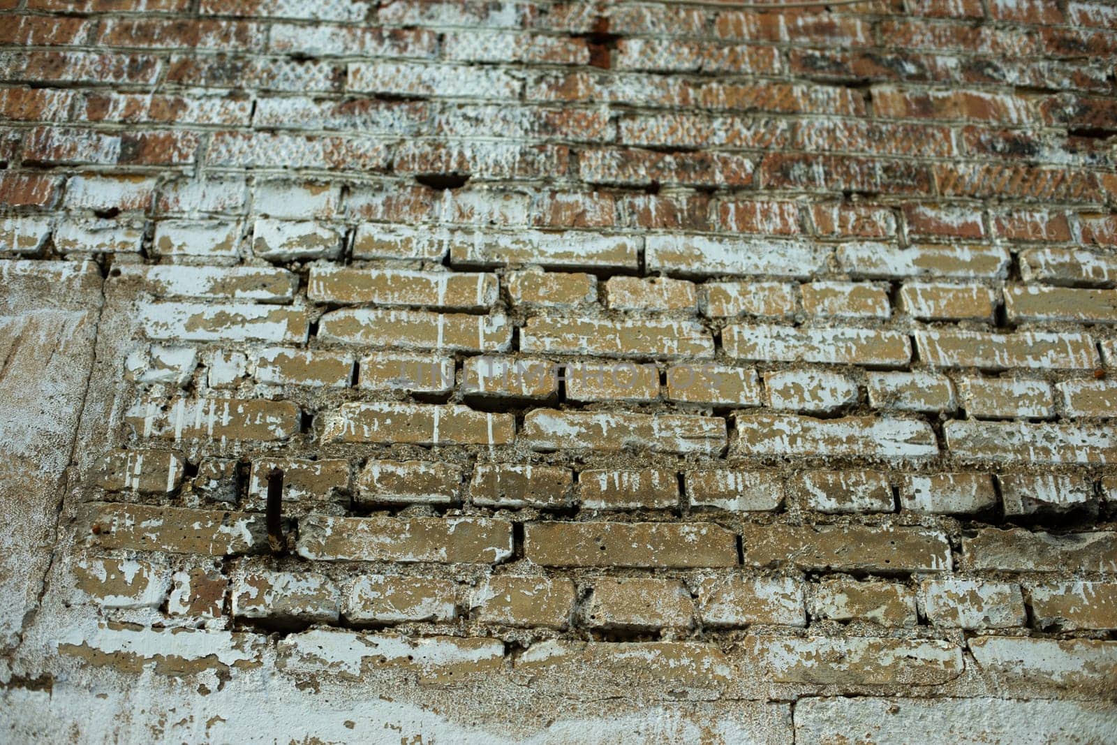 Old brick wall. Poorly painted wall of house. Details of building. White brick texture.