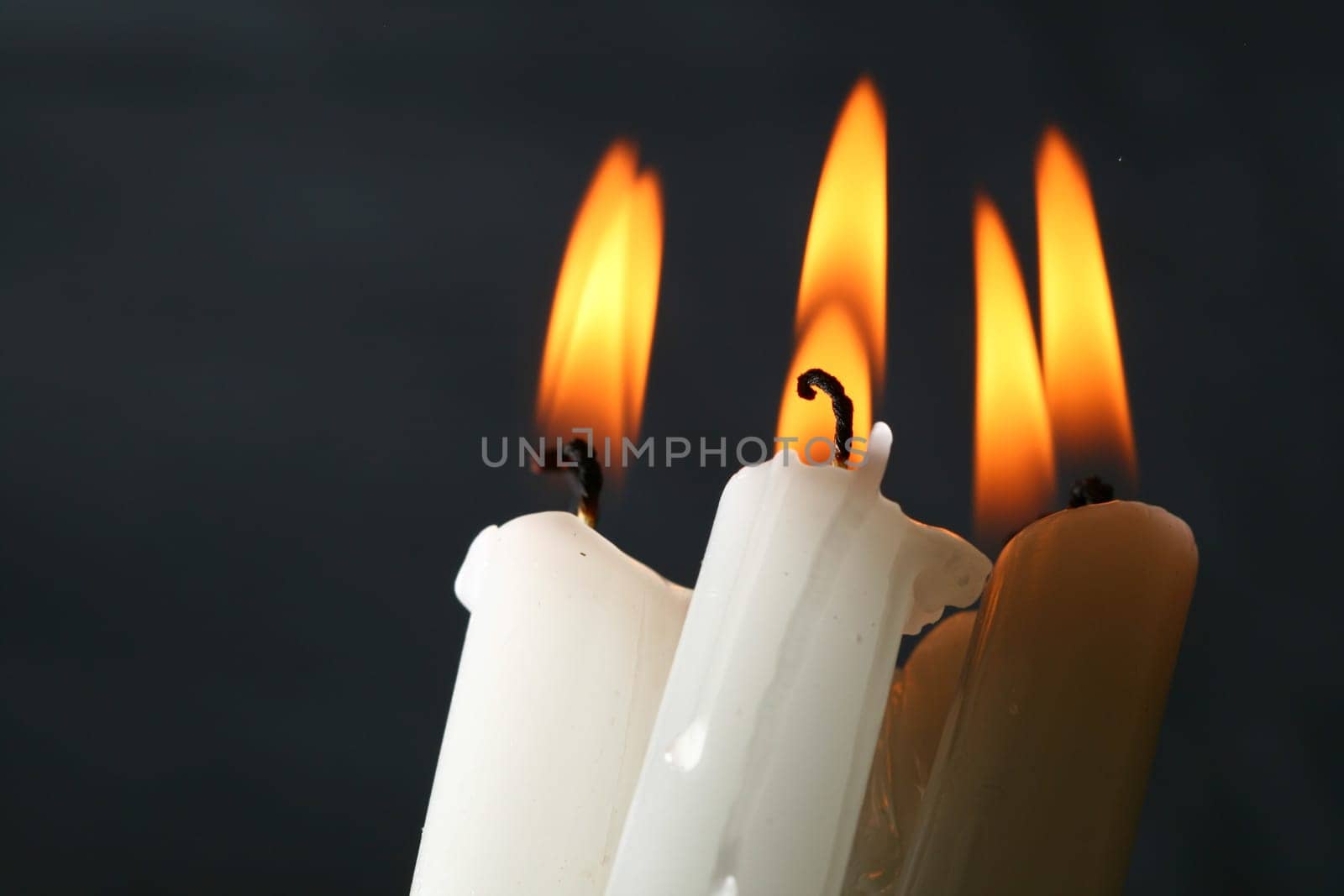 sacred candles in dark on black background
