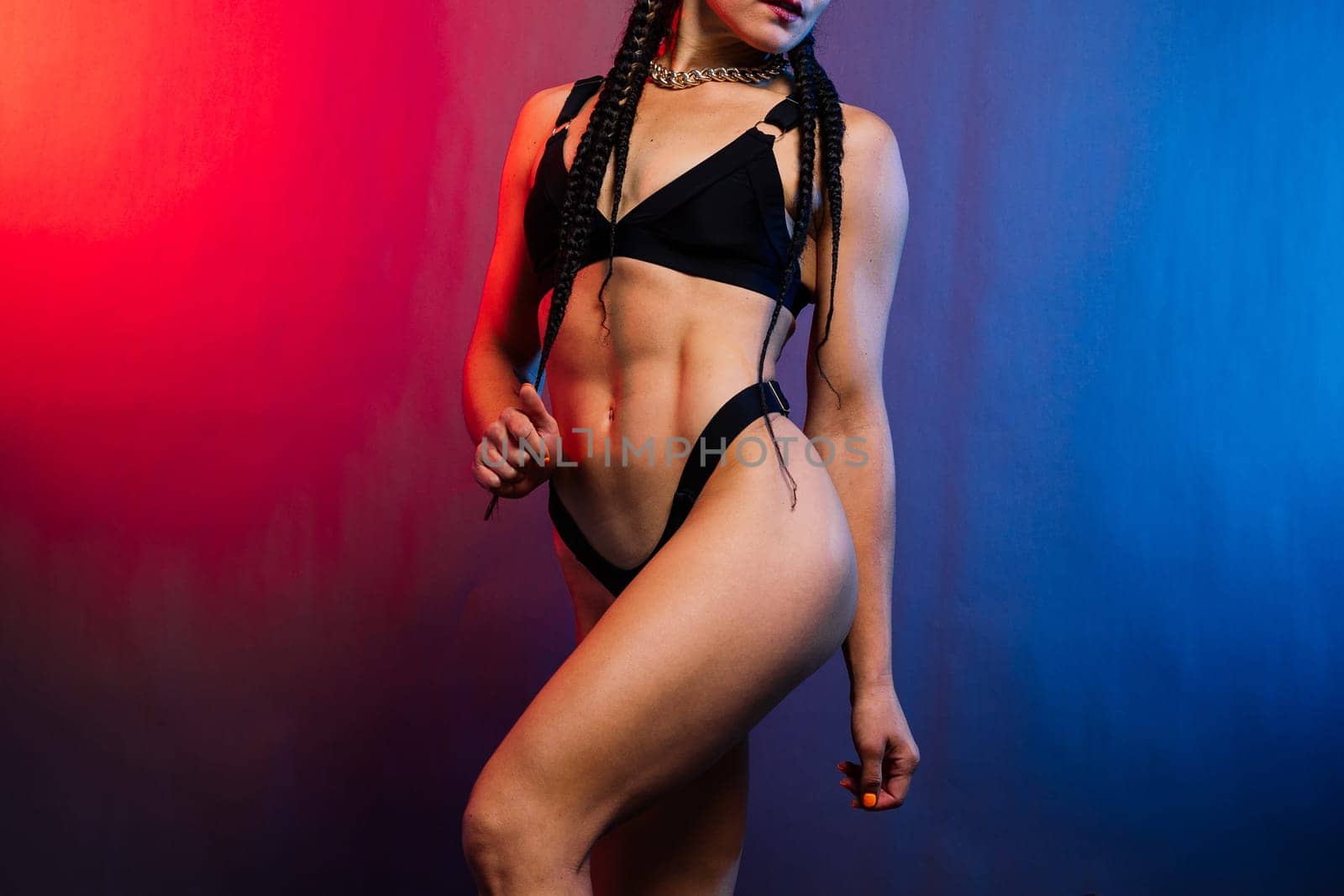 Close-up shot of young woman waist with muscular abdominal muscles. Abs of a fit female athlete.