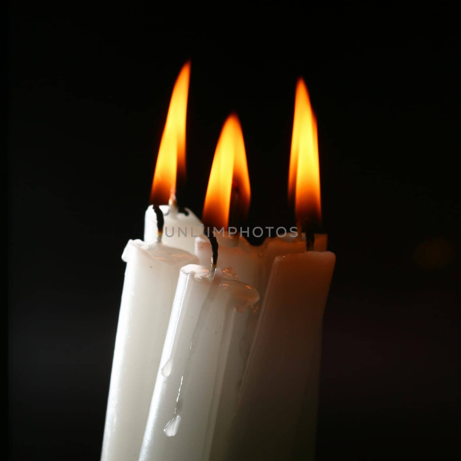 sacred candles in dark on black background