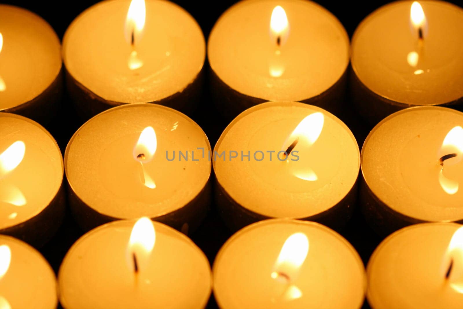 sacred candles in dark on black background