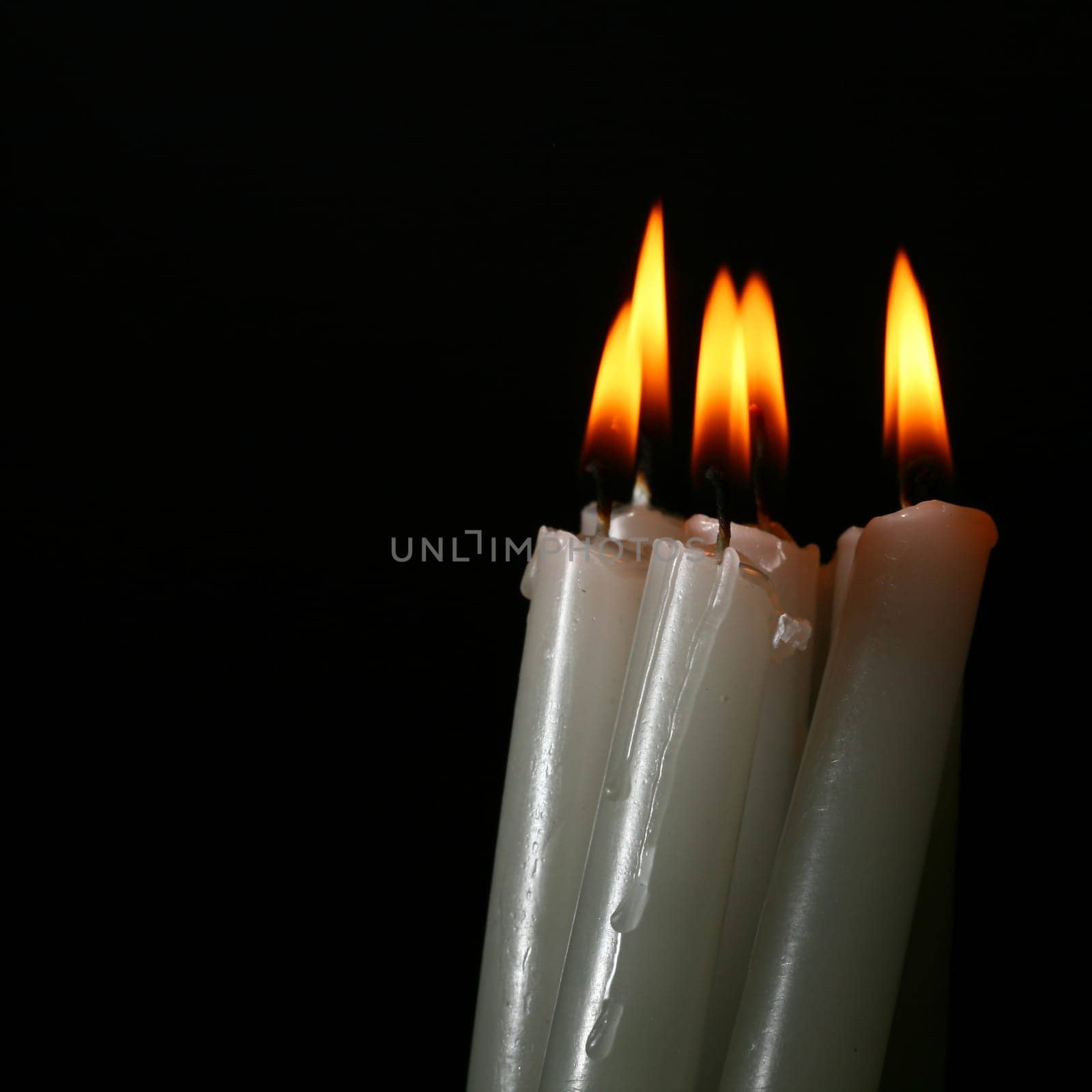 sacred candles in dark on black background