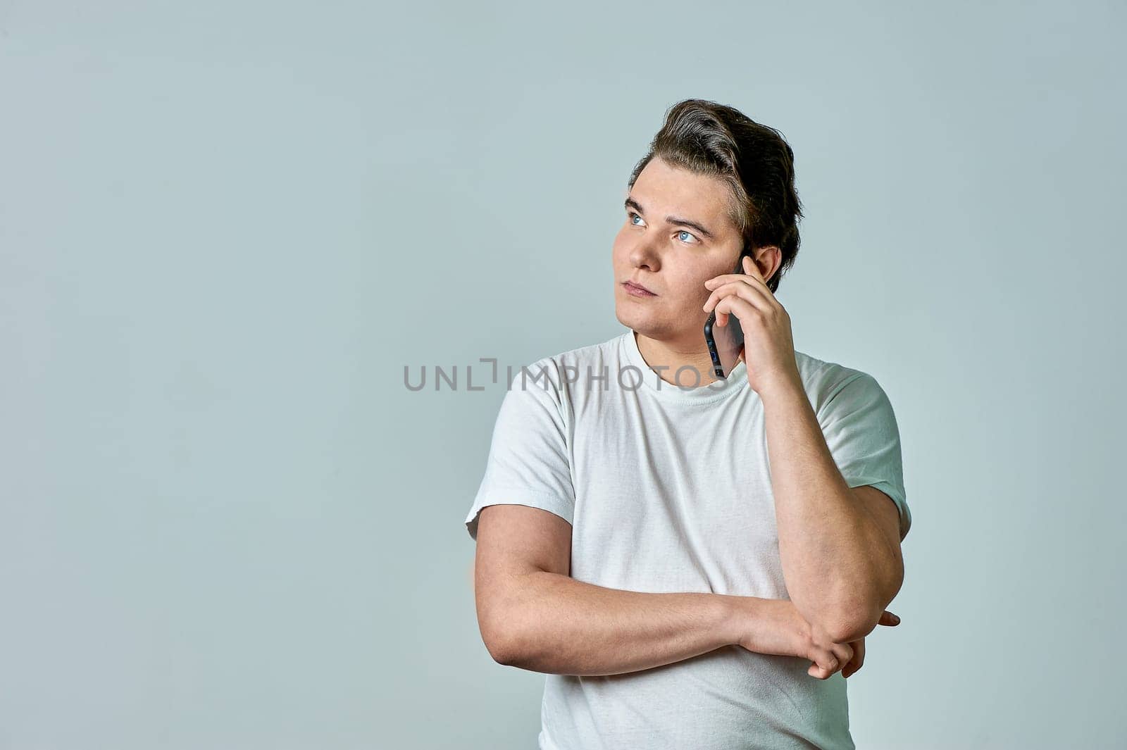a man on a gray background is talking on the phone. High quality photo