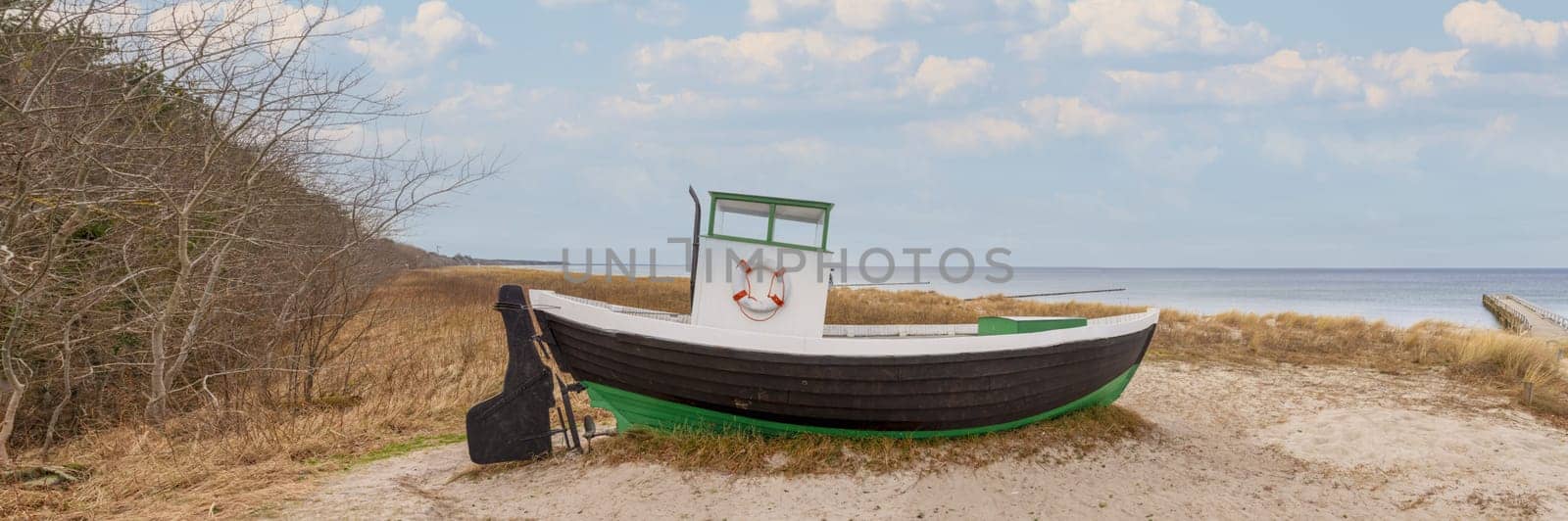 an old wooden fishing cutter on the beach of Zingst on the Baltic Sea. A landmark of traditional fishing and a popular holiday destination for tourists
