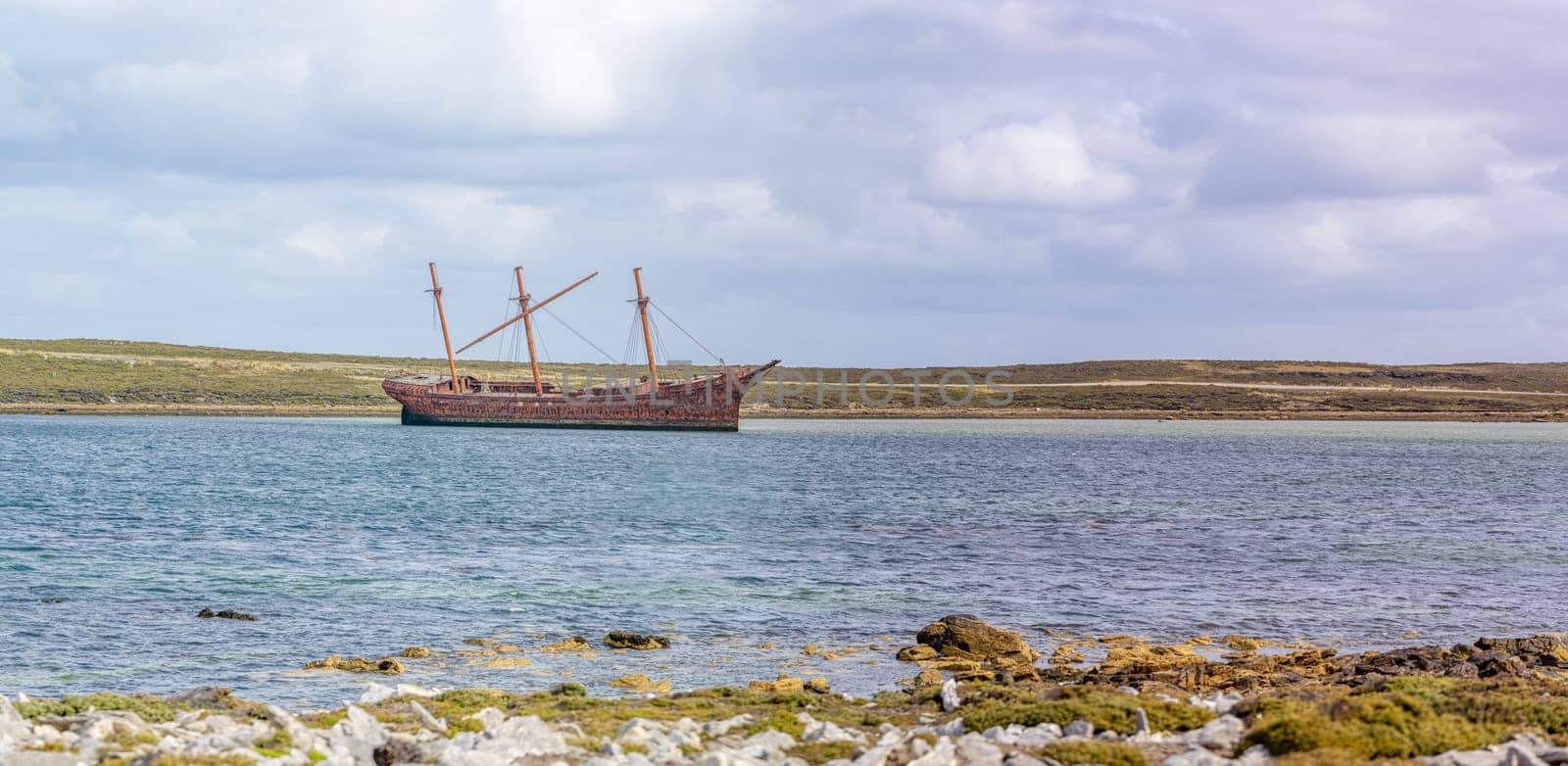 An old whaler wreck in Whalebone Cove off Stanley in the Falkland Islands. Stanley in the background