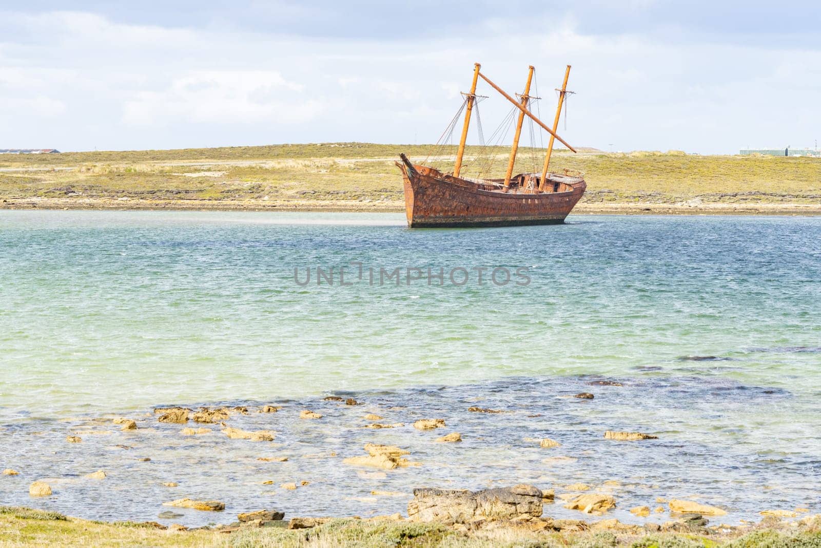 An old whaler wreck in Whalebone Cove off Stanley in the Falkland Islands. Stanley in the background
