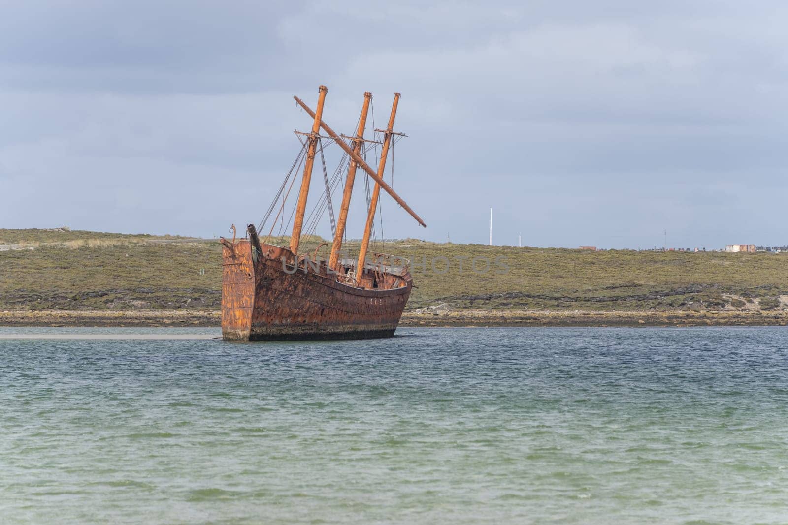 An old whaler wreck in Whalebone Cove off Stanley in the Falkland Islands. Stanley in the background
