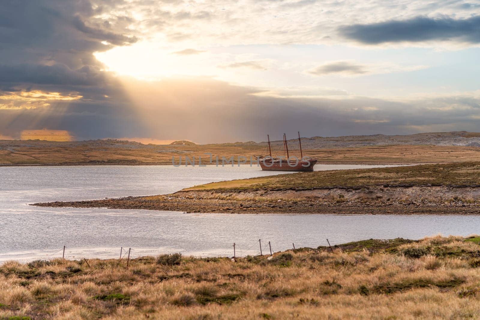 An old whaler wreck in Whalebone Cove off Stanley in the Falkland Islands. Stanley in the background