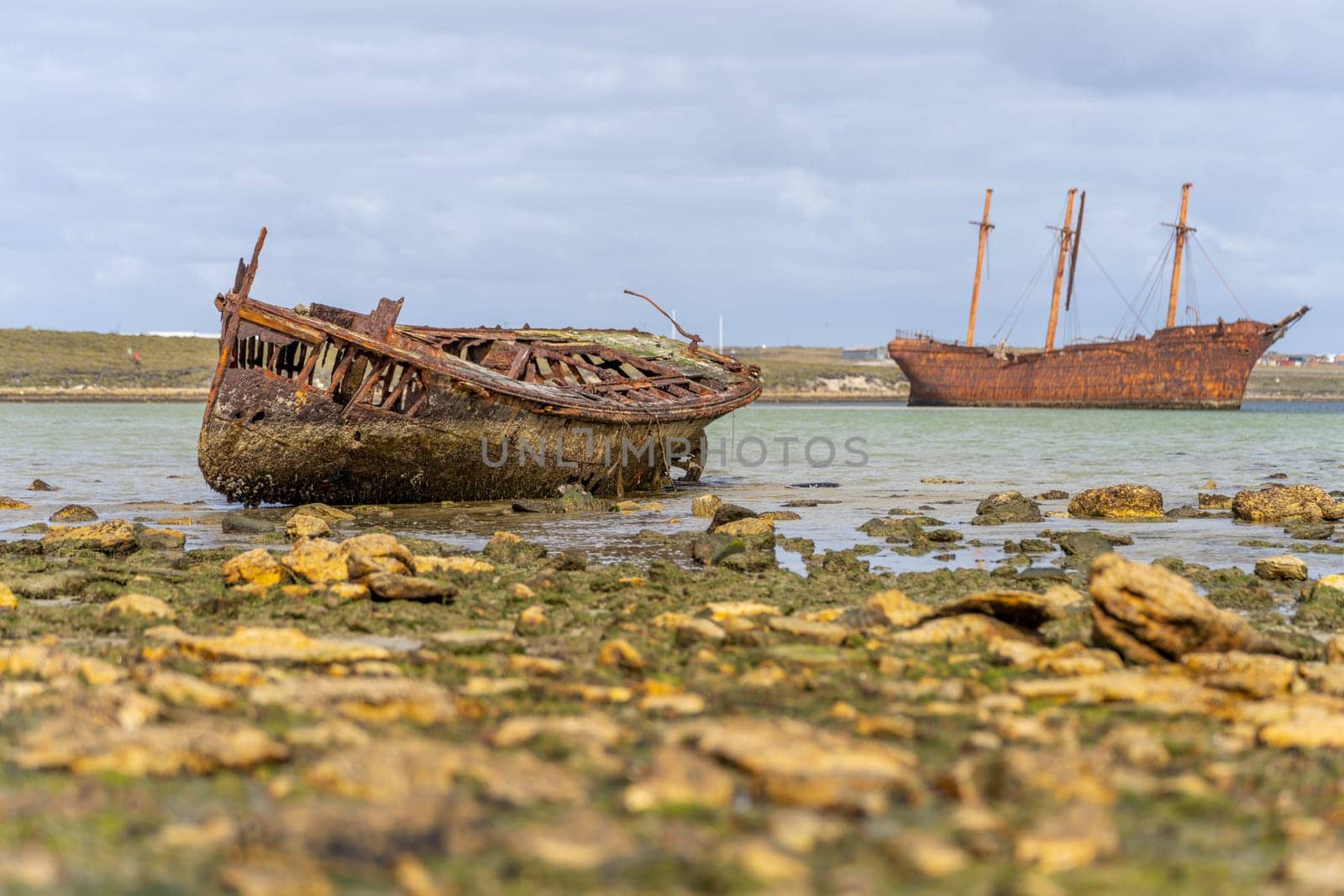 An old whaler wreck in Whalebone Cove off Stanley in the Falkland Islands. Stanley in the background