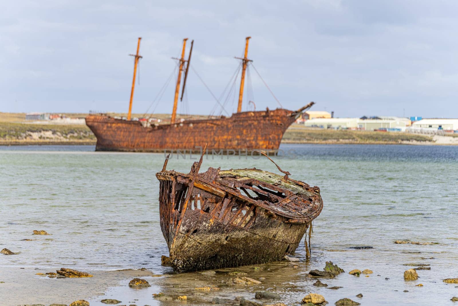 An old whaler wreck in Whalebone Cove off Stanley in the Falkland Islands. Stanley in the background
